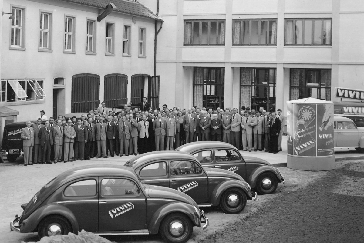 Altes Bild der VIVIL Produktion und Verwaltung mit Autos und Belegschaft