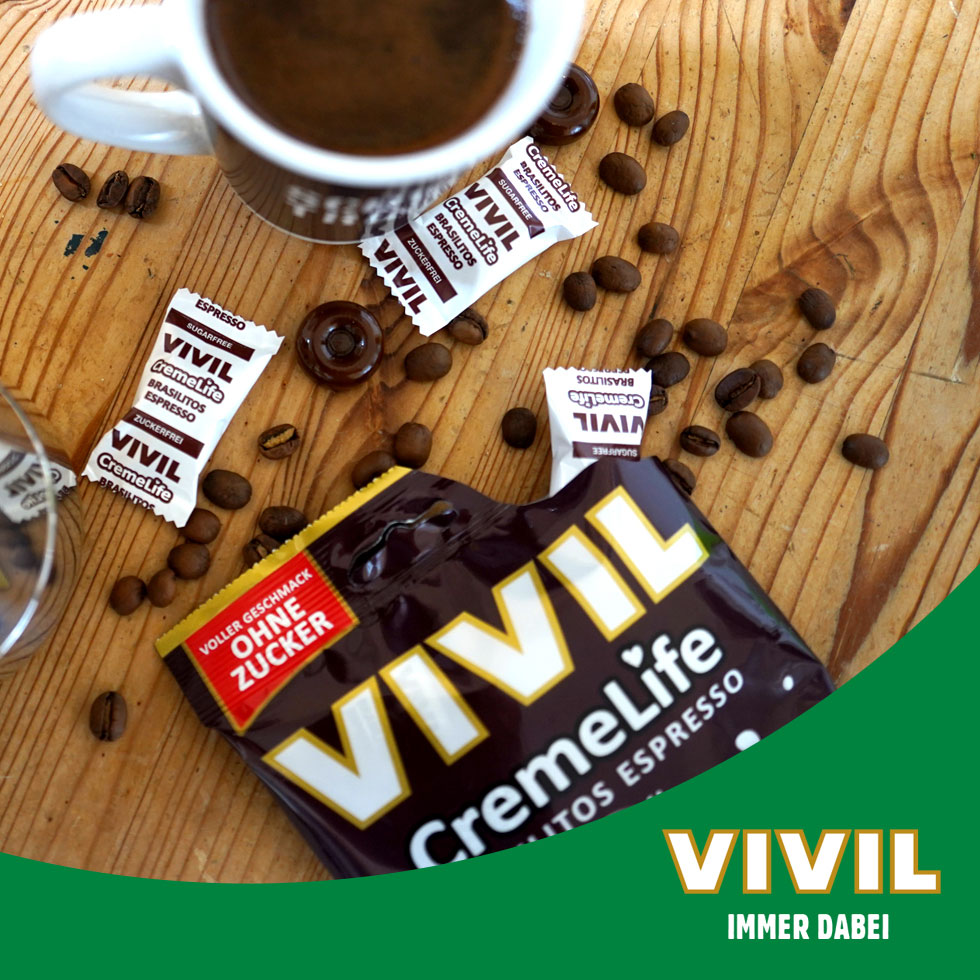 VIVIL Creme Life Brasilitos Bonbonverpackung neben Kaffeetasse VIVIL Creme Life Brasilitos Bonbonverpackung neben Kaffeetasse